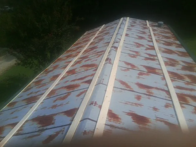 Rusted metal roof panels with new wood purlins before replacement — Storm Damage Roof Repair in Fairhaven by Roofing Brothers