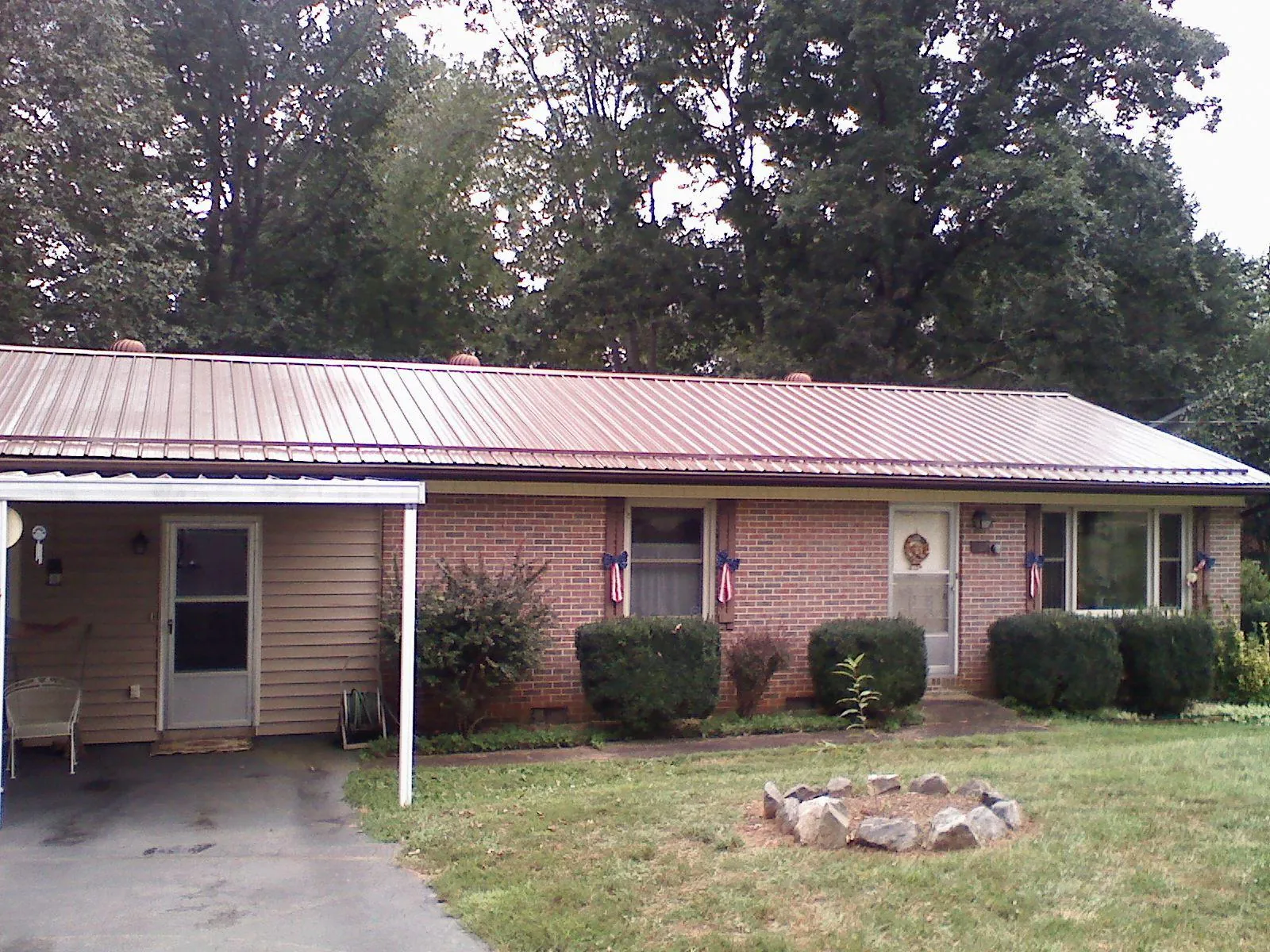 Bronze metal roof and carport on a brick ranch home — Roof Repair work by our crew in Fairhaven